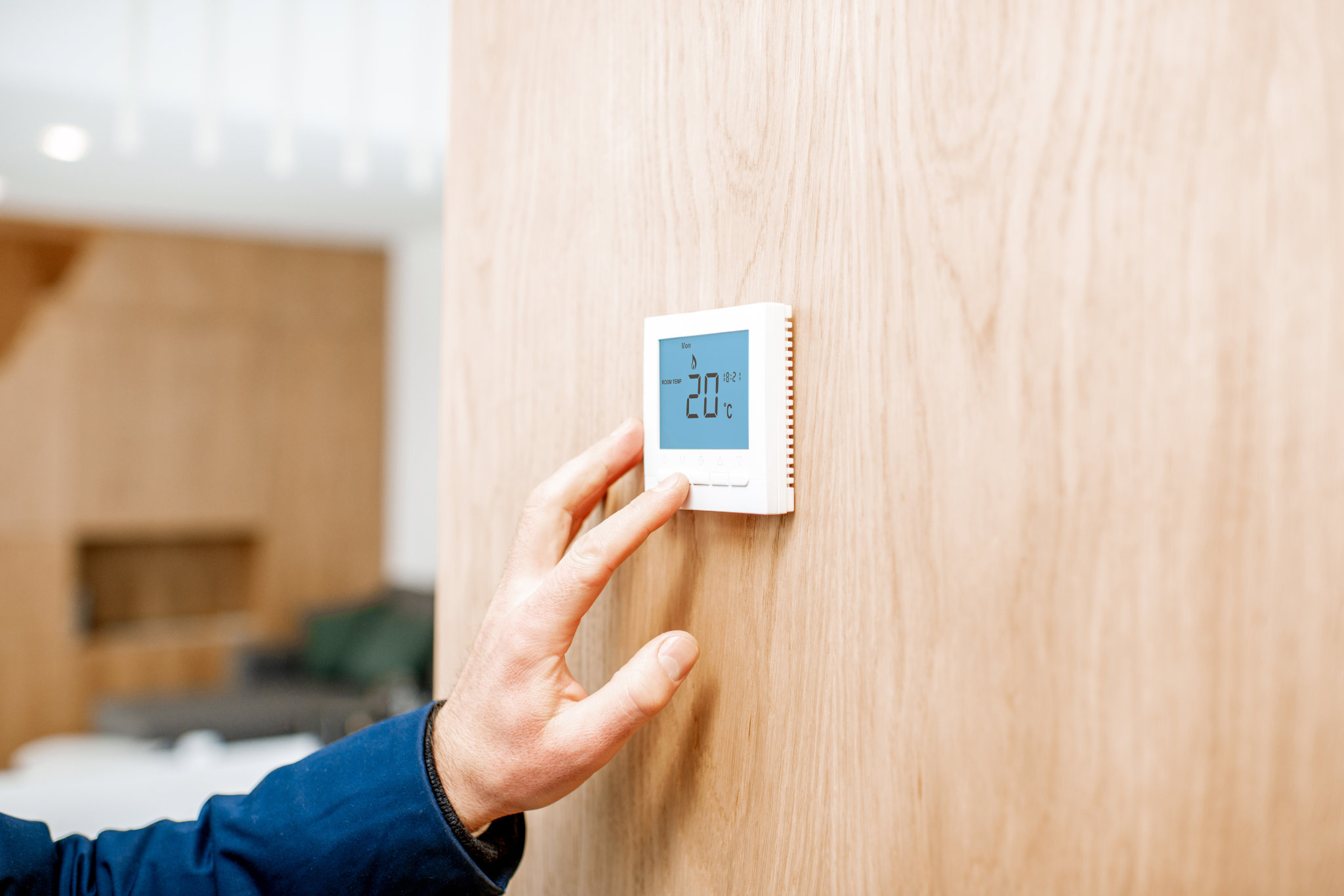 Ajuste de la temperatura ambiente con termostato electrónico en casa, vista de primer plano sin rostro